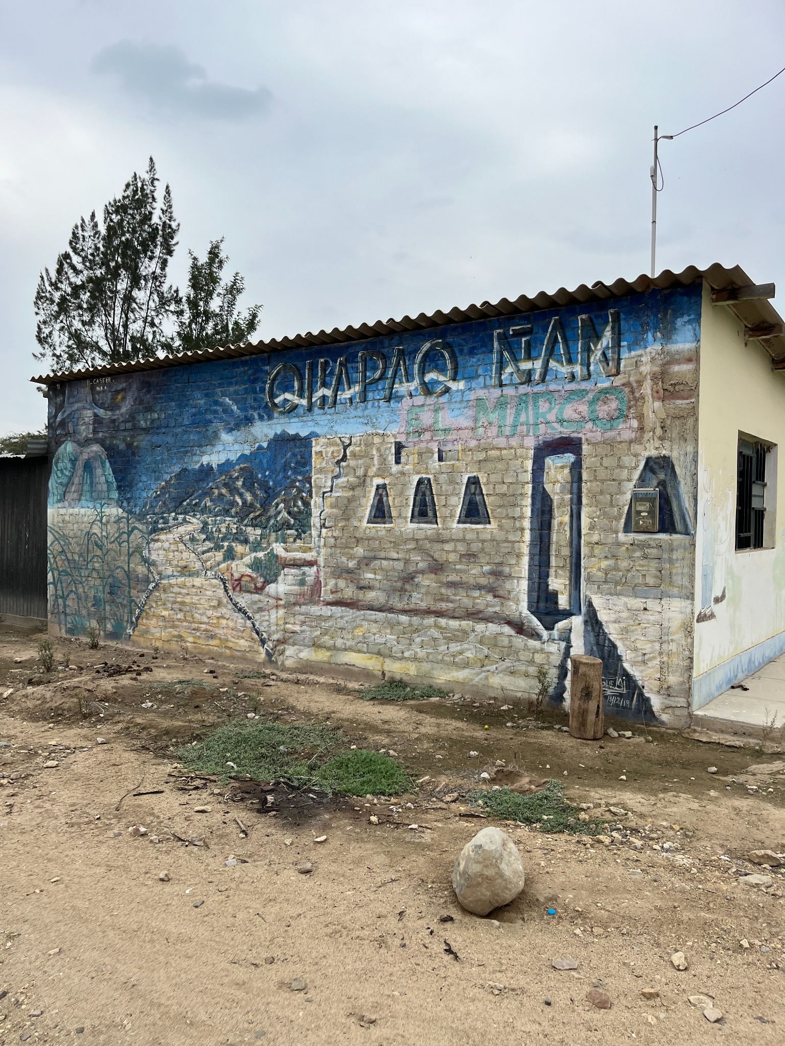 Mural con la inscripción Qhapaq Ñan y El Marco en la fachada de una edificación